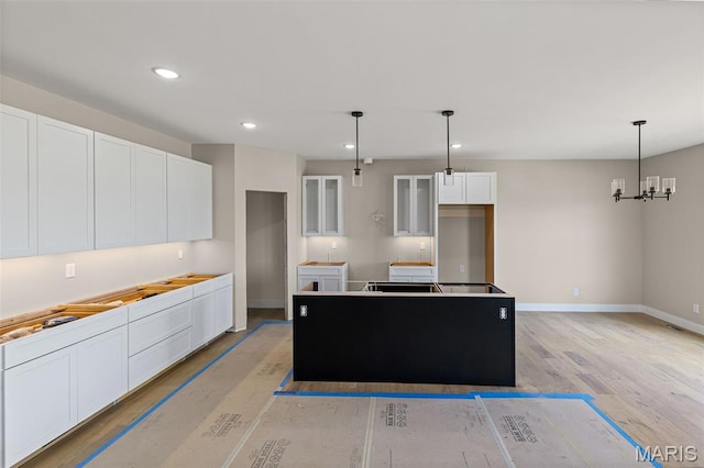 3131 Ashley Dr, Glen Carbon, IL 62034 - kitchen featuring white cabinetry, recessed lighting, a kitchen island, hanging light fixtures, and light wood-style flooring