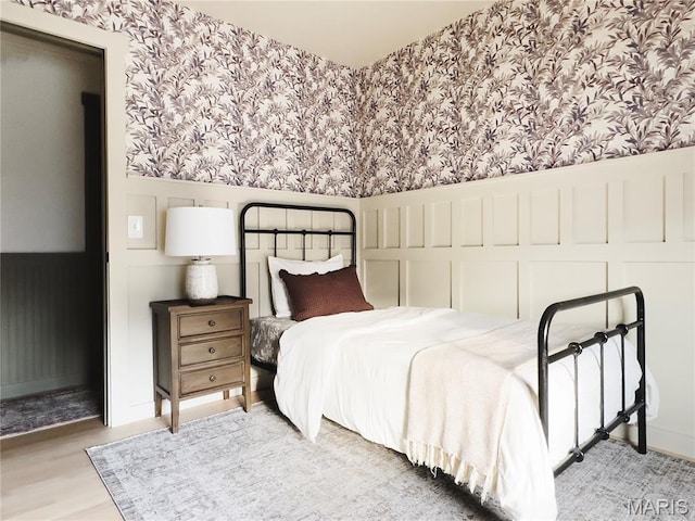 10 Marcus Dr, Saint Peters, MO 63376 - bedroom featuring wallpapered walls, a wainscoted wall, a decorative wall, and wood finished floors