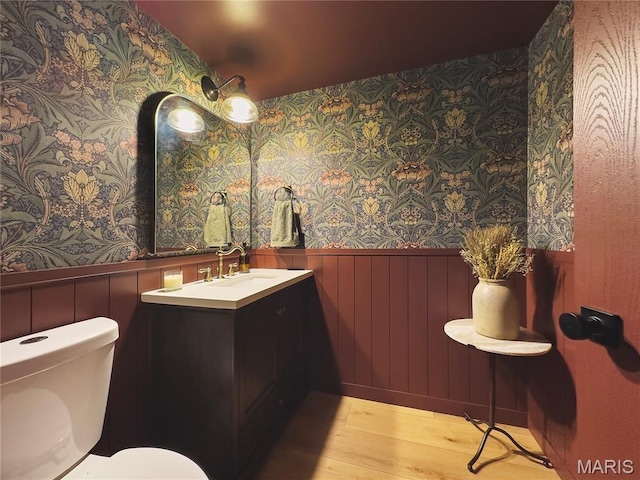 10 Marcus Dr, Saint Peters, MO 63376 - bathroom featuring wallpapered walls, a wainscoted wall, vanity, and wood finished floors