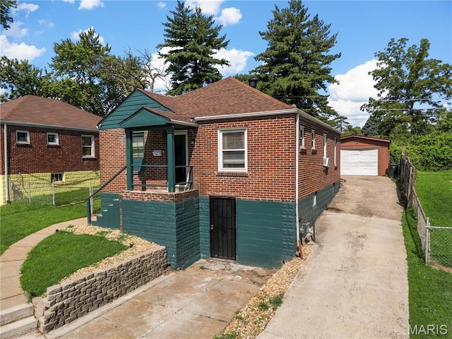 5211 Fletcher St, Jennings, MO 63136 - view of front of home with driveway, an outdoor structure, brick siding, and a detached garage