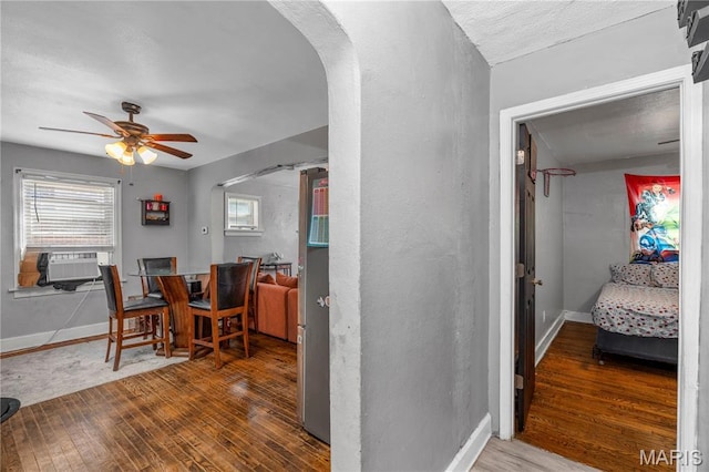 5211 Fletcher St, Jennings, MO 63136 - dining room featuring wood finished floors, ceiling fan, arched walkways, and cooling unit