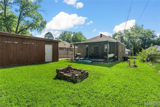 5211 Fletcher St, Jennings, MO 63136 - view of yard featuring a fire pit, an outdoor structure, and a patio area
