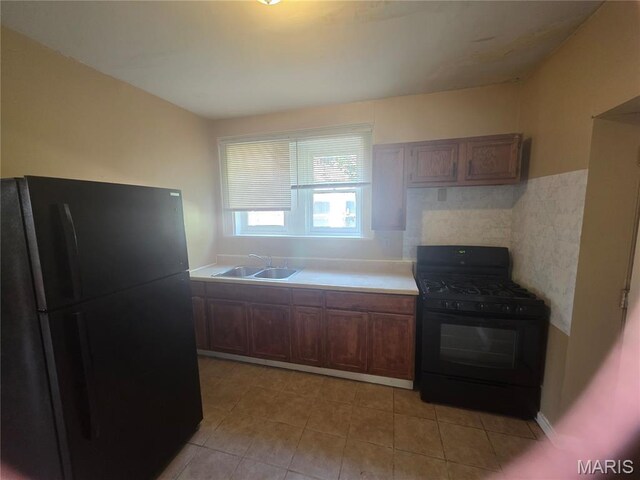 3421 Belt Ave, Saint Louis, MO 63120 - kitchen featuring black appliances, light tile patterned flooring, light countertops, backsplash, and brown cabinets