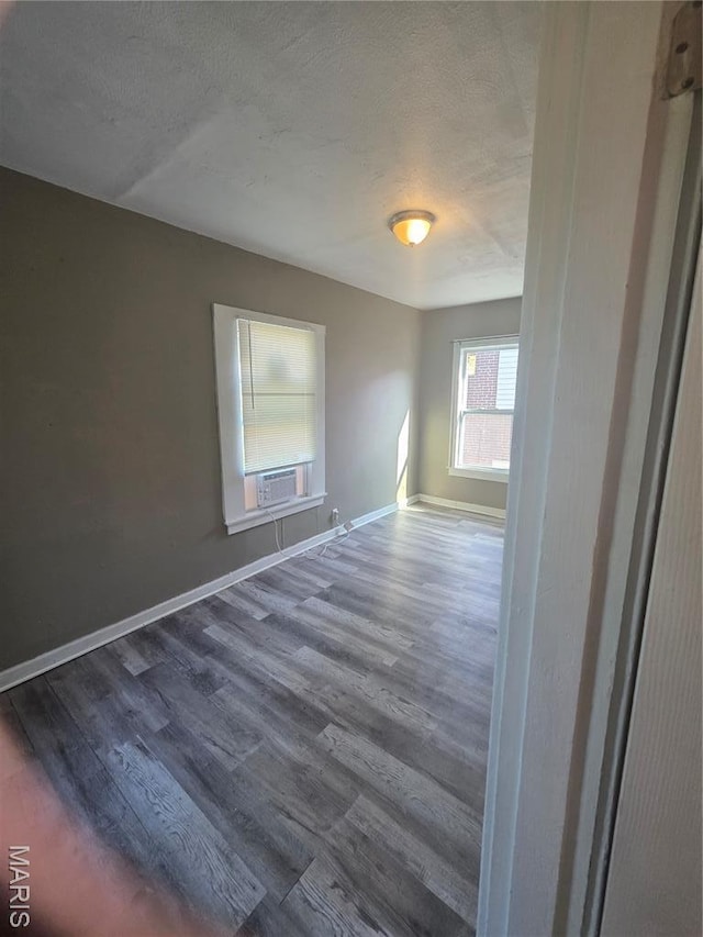 3421 Belt Ave, Saint Louis, MO 63120 - empty room featuring dark wood-style flooring, a textured ceiling, and cooling unit
