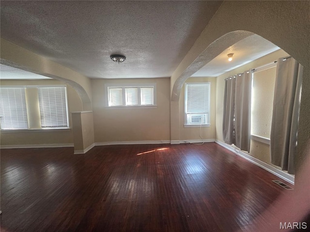 3421 Belt Ave, Saint Louis, MO 63120 - unfurnished room featuring hardwood / wood-style flooring, arched walkways, and a textured ceiling