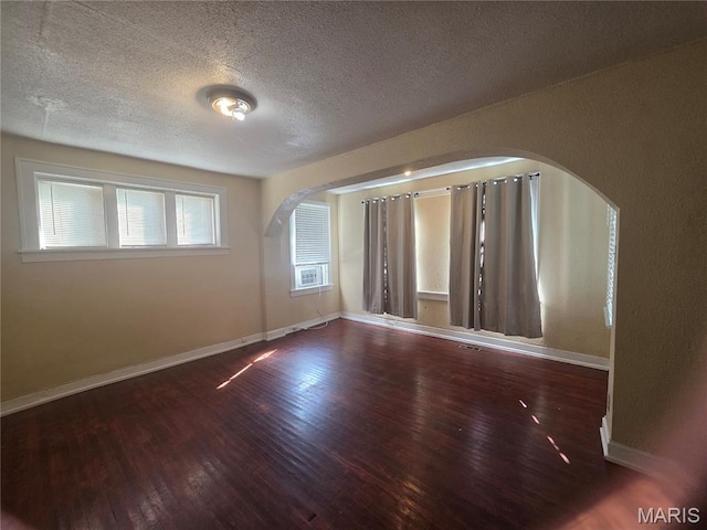 3421 Belt Ave, Saint Louis, MO 63120 - spare room with wood finished floors, arched walkways, and a textured ceiling