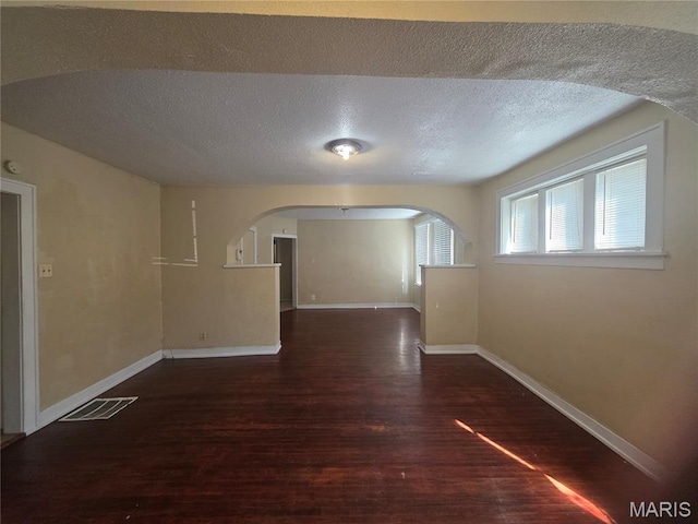 3421 Belt Ave, Saint Louis, MO 63120 - spare room with wood finished floors, arched walkways, and a textured ceiling
