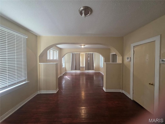 3421 Belt Ave, Saint Louis, MO 63120 - hall featuring wood-type flooring, a textured ceiling, and arched walkways