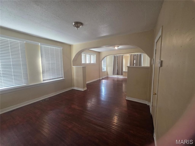 3421 Belt Ave, Saint Louis, MO 63120 - unfurnished room with arched walkways, wood finished floors, and a textured ceiling