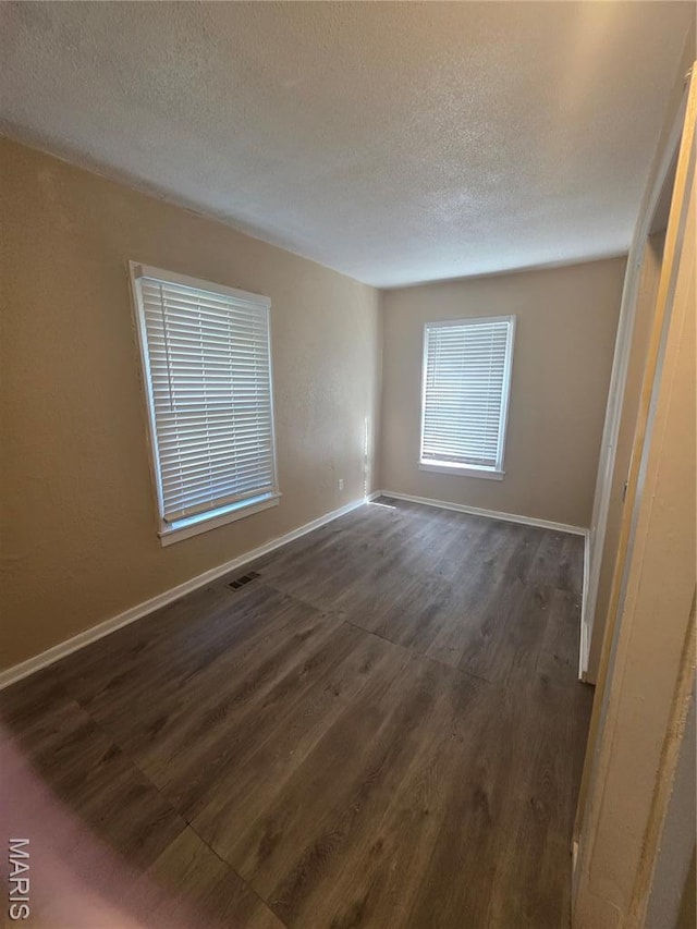 3421 Belt Ave, Saint Louis, MO 63120 - spare room with dark wood-style floors and a textured ceiling