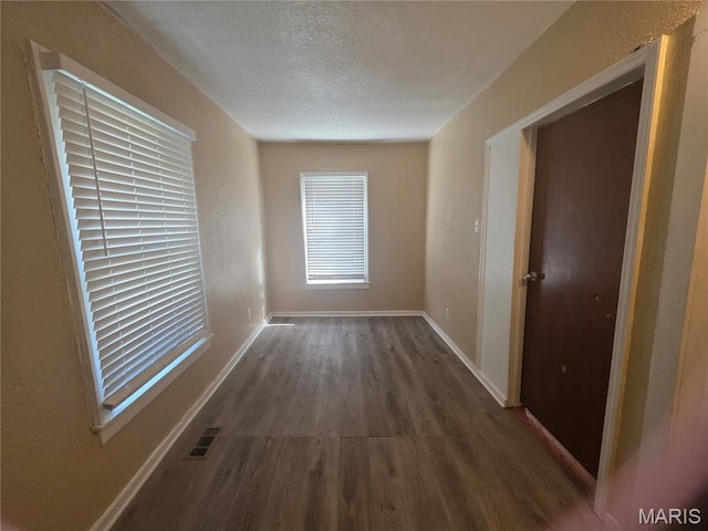 3421 Belt Ave, Saint Louis, MO 63120 - hall with dark wood-style floors and a textured ceiling