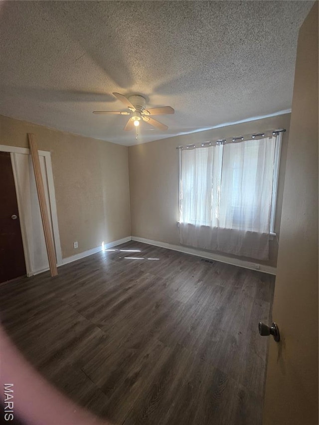 3421 Belt Ave, Saint Louis, MO 63120 - empty room featuring a textured ceiling, dark wood finished floors, and ceiling fan