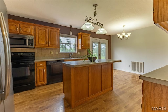 136 County Road 4415, Poplar Bluff, MO 63901 - kitchen with black appliances, backsplash, a kitchen island, brown cabinetry, and light wood-style floors