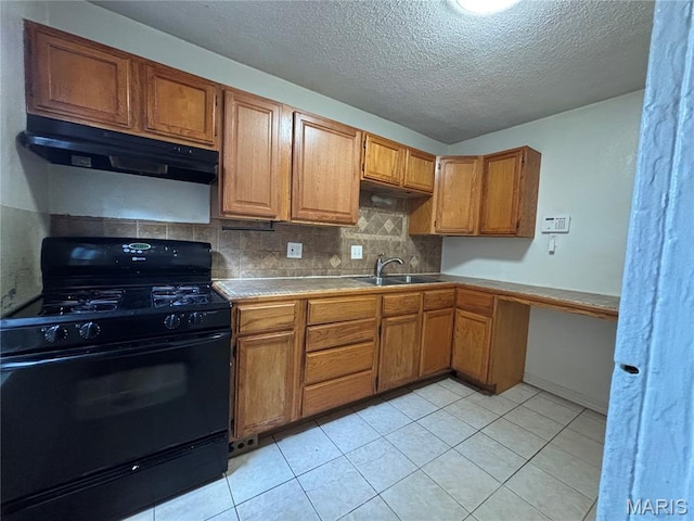 6104 N Pointe Blvd, Saint Louis, MO 63147 - kitchen with black range with gas stovetop, under cabinet range hood, tile countertops, decorative backsplash, and brown cabinetry