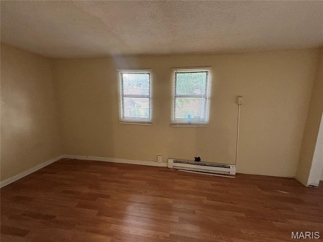6104 N Pointe Blvd, Saint Louis, MO 63147 - spare room featuring a baseboard radiator, wood finished floors, and a textured ceiling