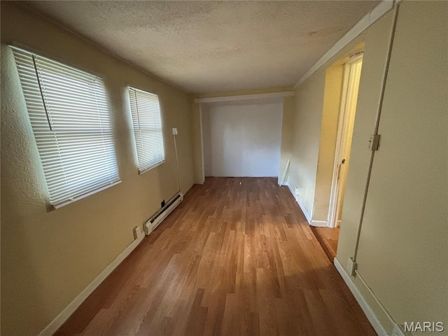 6104 N Pointe Blvd, Saint Louis, MO 63147 - hall featuring baseboard heating, wood finished floors, and a textured ceiling