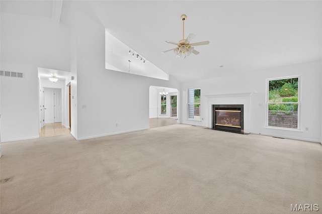 36 Mountain Laurel Dr, Saint Peters, MO 63376 - unfurnished living room featuring high vaulted ceiling, a ceiling fan, carpet floors, a fireplace with flush hearth, and a chandelier