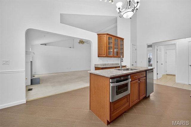 36 Mountain Laurel Dr, Saint Peters, MO 63376 - kitchen with stainless steel appliances, open floor plan, glass insert cabinets, a center island with sink, and a chandelier