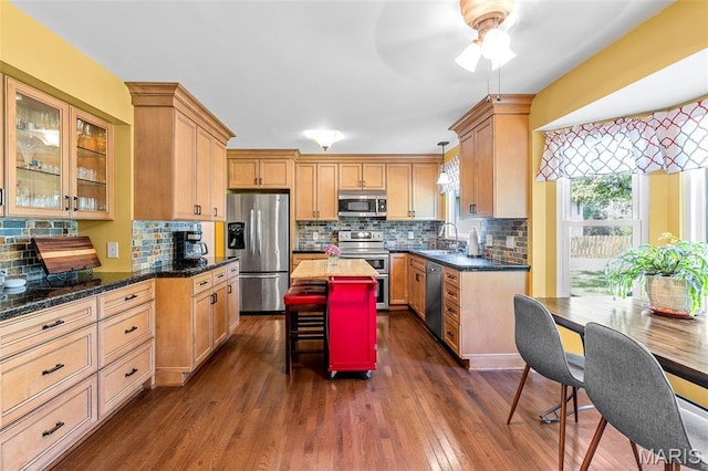 307 Blue Ridge Place Ct, Ballwin, MO 63011 - kitchen featuring appliances with stainless steel finishes, dark wood-style floors, a center island, tasteful backsplash, and glass insert cabinets