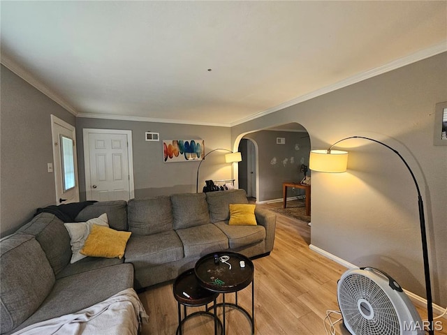 2060 Washington St, Florissant, MO 63033 - living room featuring light wood finished floors, arched walkways, and crown molding