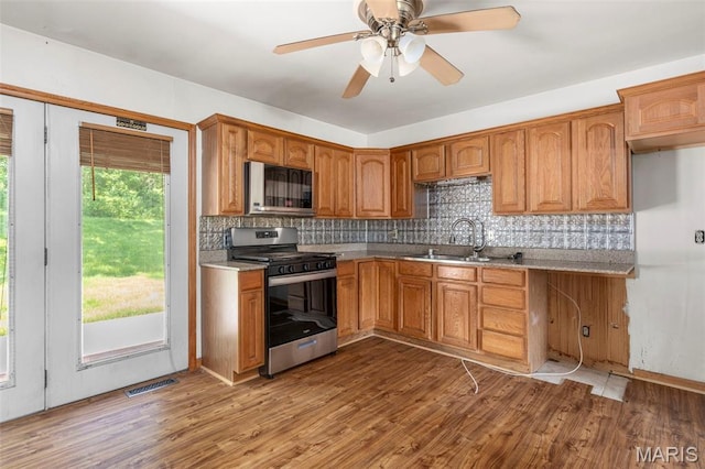 5311 Grove Ave, Ferguson, MO 63135 - kitchen featuring stainless steel appliances, backsplash, wood finished floors, ceiling fan, and light countertops
