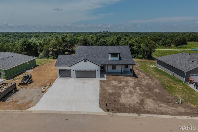 1817 Vadie Ave, Lebanon, MO 65536 - modern farmhouse featuring a wooded view, a garage, driveway, and covered porch