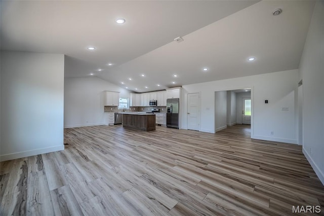 1817 Vadie Ave, Lebanon, MO 65536 - unfurnished living room with vaulted ceiling, light wood-style floors, and recessed lighting