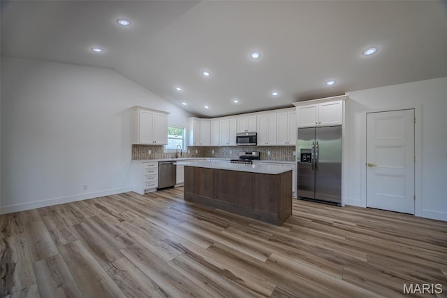 1817 Vadie Ave, Lebanon, MO 65536 - kitchen with stainless steel appliances, vaulted ceiling, a center island, white cabinetry, and light countertops