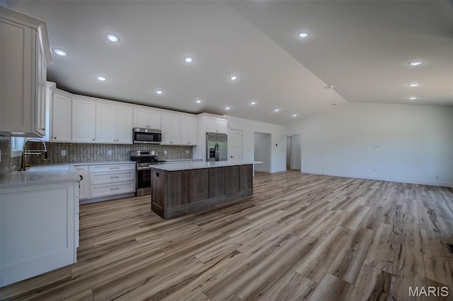 1817 Vadie Ave, Lebanon, MO 65536 - kitchen featuring stainless steel appliances, open floor plan, lofted ceiling, backsplash, and a kitchen island