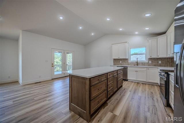 1817 Vadie Ave, Lebanon, MO 65536 - kitchen with appliances with stainless steel finishes, light wood-style flooring, white cabinets, lofted ceiling, and recessed lighting