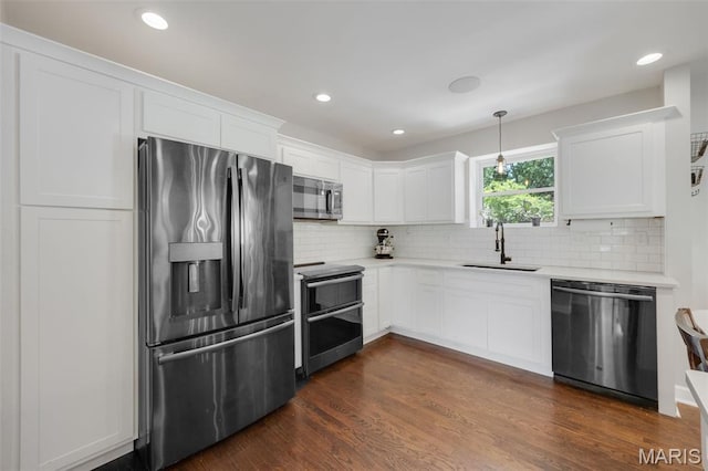 7700 Weil Ave, Saint Louis, MO 63119 - kitchen featuring appliances with stainless steel finishes, light countertops, white cabinets, decorative backsplash, and recessed lighting