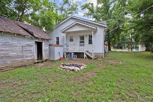 204 E Jefferson St, Potosi, MO 63664 - rear view of property featuring a storage shed, a detached carport, and a yard