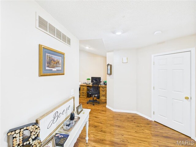 1110 State Highway Ad, Dexter, MO 63841 - corridor with an office area, light wood-style floors, and a textured ceiling