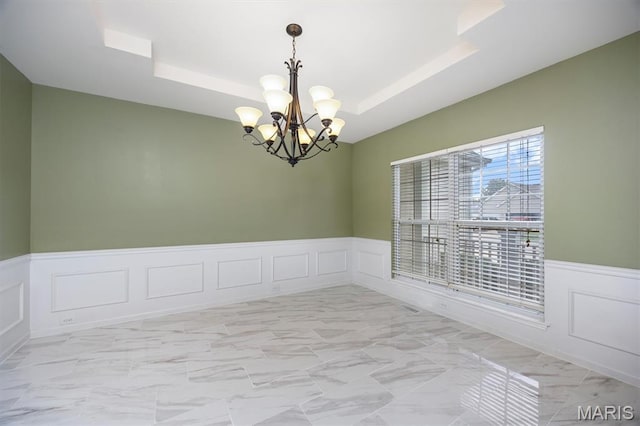 1305 Monarch Lake Ln, Shiloh, IL 62221 - unfurnished room featuring a decorative wall, a tray ceiling, a chandelier, wainscoting, and light marble finish floors
