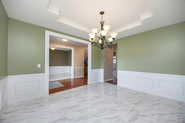 1305 Monarch Lake Ln, Shiloh, IL 62221 - unfurnished room featuring a decorative wall, a wainscoted wall, a raised ceiling, a chandelier, and marble finish floors