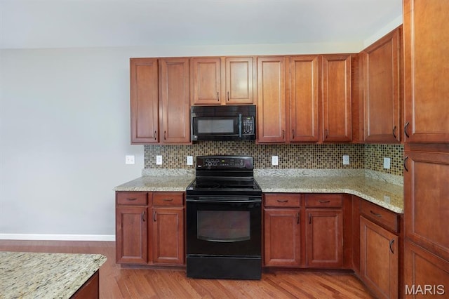 1305 Monarch Lake Ln, Shiloh, IL 62221 - kitchen featuring black appliances, light wood finished floors, decorative backsplash, and light stone counters