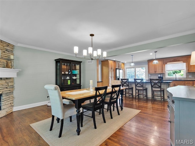 1571 Yarmouth Point Dr, Chesterfield, MO 63017 - dining area featuring a chandelier, crown molding, dark wood-style flooring, and a fireplace