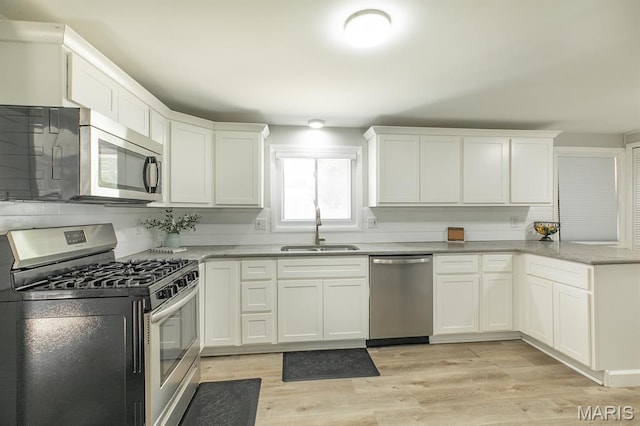 250 Hi Pointe Pl, East Alton, IL 62024 - kitchen with stainless steel appliances, white cabinets, a peninsula, and light wood-type flooring