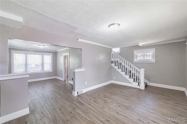 1105 Pennsylvania Ave, Saint Louis, MO 63130 - unfurnished room featuring crown molding, a textured ceiling, stairs, and wood finished floors