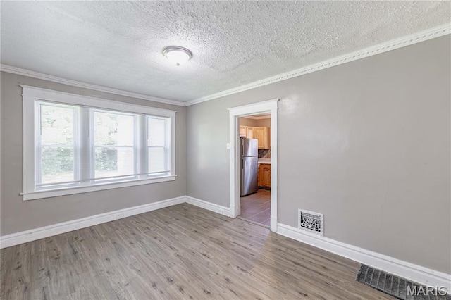 1105 Pennsylvania Ave, Saint Louis, MO 63130 - spare room with a textured ceiling, crown molding, and light wood-style flooring