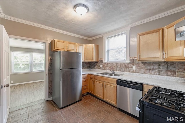 1105 Pennsylvania Ave, Saint Louis, MO 63130 - kitchen with stainless steel appliances, light countertops, light brown cabinetry, decorative backsplash, and crown molding
