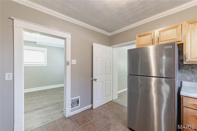1105 Pennsylvania Ave, Saint Louis, MO 63130 - kitchen featuring freestanding refrigerator, light brown cabinetry, ornamental molding, light countertops, and decorative backsplash
