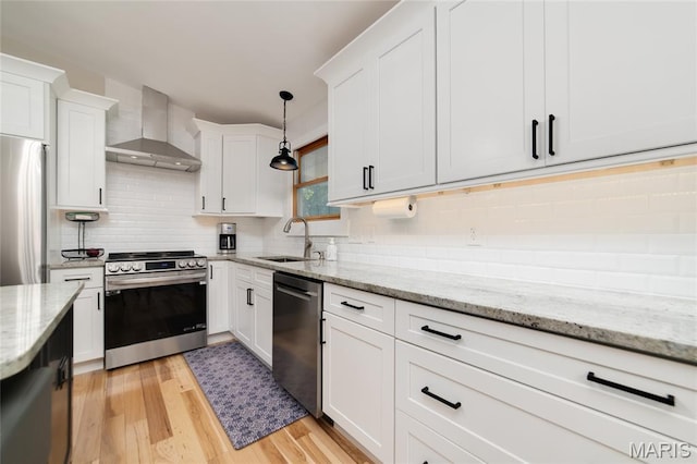 8870 State Road Nn, Cedar Hill, MO 63016 - kitchen featuring appliances with stainless steel finishes, wall chimney range hood, light wood-style flooring, tasteful backsplash, and white cabinets