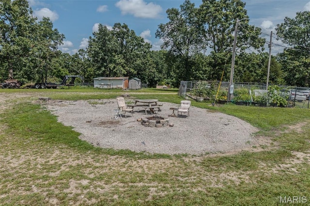 30053 Emily Ln, Lebanon, MO 65536 - view of yard featuring an outdoor fire pit, a storage unit, and view of wooded area