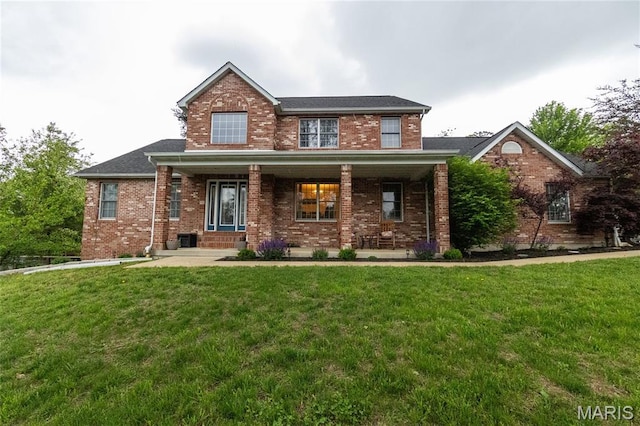 11907 Pine Forest Dr, Rolla, MO 65401 - traditional home featuring brick siding, a front yard, and covered porch