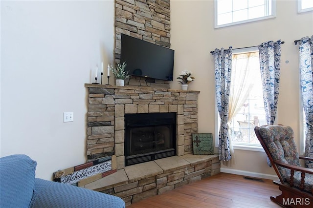 11907 Pine Forest Dr, Rolla, MO 65401 - living room with wood finished floors, a fireplace, and plenty of natural light