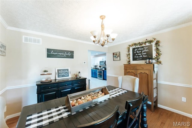 11907 Pine Forest Dr, Rolla, MO 65401 - dining room with a chandelier, wood finished floors, crown molding, and a textured ceiling