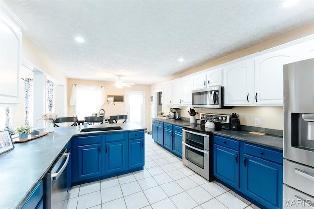 11907 Pine Forest Dr, Rolla, MO 65401 - kitchen featuring stainless steel appliances, blue cabinets, white cabinets, recessed lighting, and a peninsula
