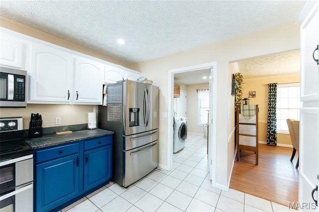 11907 Pine Forest Dr, Rolla, MO 65401 - kitchen with appliances with stainless steel finishes, dark countertops, blue cabinets, white cabinets, and a textured ceiling