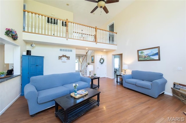11907 Pine Forest Dr, Rolla, MO 65401 - living area featuring ceiling fan, stairway, a high ceiling, and wood finished floors